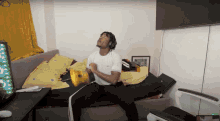 a man wearing headphones is sitting on a bed in a bedroom