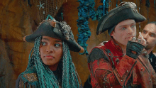 a woman with blue braids and a man in a pirate outfit