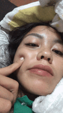 a close up of a woman 's face with a finger on it