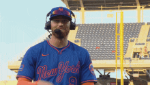 a man wearing headphones and a new york baseball jersey