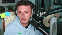 a man wearing headphones is sitting in front of a microphone with a sticker on the chair that says tyrell