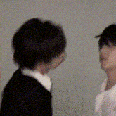 a man and a woman are standing next to each other and looking at each other .