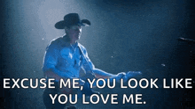 a man in a cowboy hat is playing a guitar and says excuse me you look like you love me .