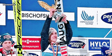 a man holding up a trophy with the word aug on it
