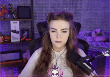 a woman sitting in front of a shure microphone