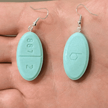 a pair of earrings made out of pills with the number 887 2 on them