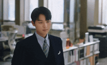 a man in a suit and tie stands in a room