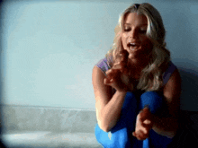 a woman in a purple shirt and blue pants is kneeling down with her mouth open