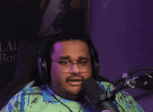 a man wearing glasses and headphones is sitting in front of a microphone