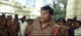 a police officer is standing in front of a crowd of people .