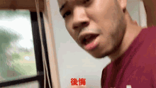 a man in a red shirt with chinese writing on the bottom