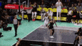 a basketball game is being played on a court with a sign that says state farm on it .