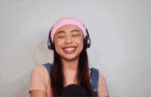 the girl is wearing headphones and a pink headband .