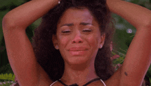 a woman with tears running down her face has a tattoo on her arm that says ' i love you '