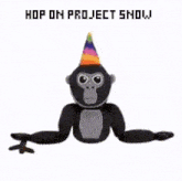 a stuffed gorilla wearing a party hat with the words hop on project show written below it .