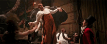 a group of people are standing around a man being lifted by an elephant in a circus .