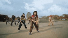 a group of people are dancing in a park with a sign that says ' 2021 '