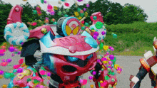 a robot is surrounded by colorful balloons and candy