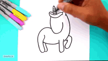 a person is drawing a unicorn on a piece of paper with sharpie markers