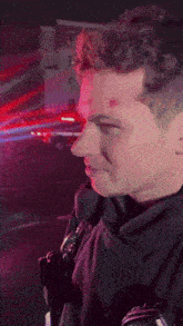 a man in a black jacket with red lights behind his eyes