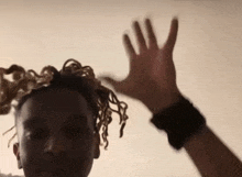 a close up of a person 's hand with dreadlocks on it .