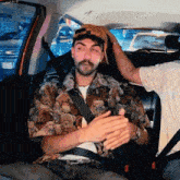 a man wearing a shirt with teddy bears on it is sitting in a car
