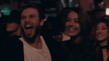 a man and a woman are laughing in a crowd of people