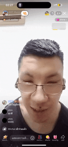 a man wearing glasses and ear buds is on a phone screen with a time of 2:27