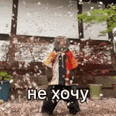a monkey is standing in front of a building with petals falling around him