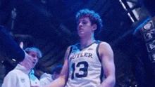 a basketball player wearing a number 13 jersey is shaking hands with a referee .