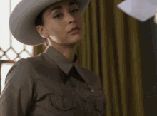 a woman wearing a cowboy hat and a badge