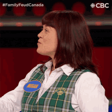 a woman in a plaid vest has a name tag that says megan on it