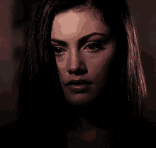 a close up of a woman 's face in a dark room