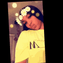 a girl wearing a yellow shirt and a flower crown on her head