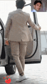 a man in a suit is getting out of a car with a picture of him in the background
