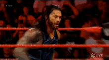 a wrestling match is taking place in a ring with a crowd in the background .