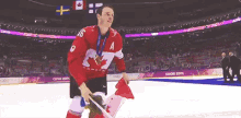 a hockey player with a medal around his neck is holding a flag