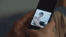 a person is taking a picture of a man on a boat