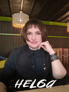 a woman sitting at a table with the name helga on the bottom right