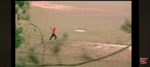 a man in a red shirt is throwing a frisbee in the air