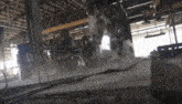 a forklift is cutting a concrete slab in a factory with smoke coming out of it