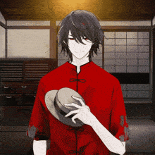 a man in a red shirt holding a hat