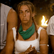 a woman wearing a green scarf around her neck is sitting in a crowd .