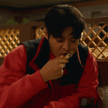 a young man is eating a piece of pizza with his mouth open .