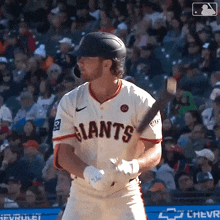 a baseball player for the giants is getting ready to swing his bat