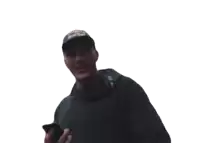 a man wearing a red bull hat is smiling and holding a cell phone