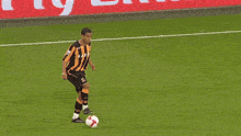 soccer players on a field with a fly emirates banner
