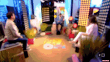 a blurry picture of people sitting in a room with the number 6 on the ground