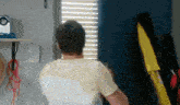a man in a yellow shirt is standing in front of a blue door