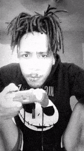 a man with dreadlocks is wearing a black shirt that says mic